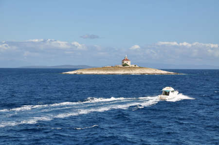 Motorboat sailing towards the lone islandの写真素材