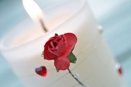 Burning white candle decorated with a rose and heart の写真素材