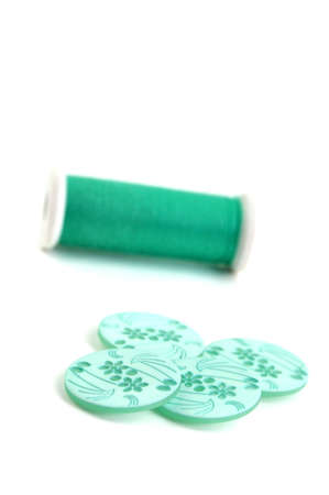 Floral turquoise buttons and thread, isolated on white background
