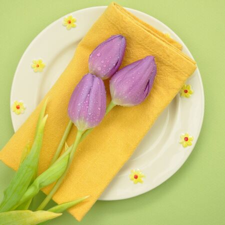 Wet purple tulips on a napkin and plate の写真素材