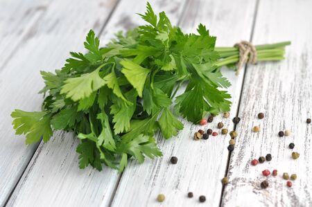 Peppercorn mix and fresh parsley on an old white table の写真素材