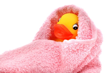Rubber duck wrapped in soft pink towel, isolated on whiteの写真素材