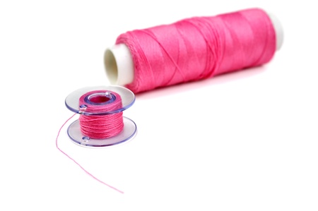 Spool and bobbin with pink threadの写真素材