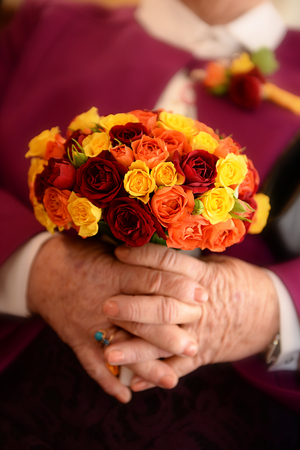 Senior woman holding colorful wedding bouquetの写真素材