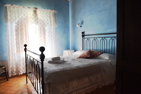 room interior with old metal bed and blue wallsの写真素材