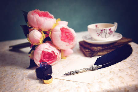 Vintage feather pen and bottle of ink on tableの写真素材