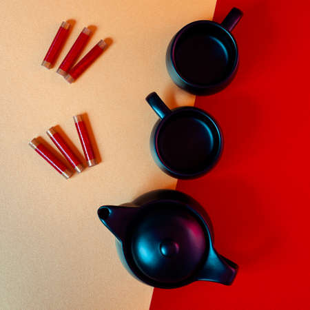 Chinese New Year gold and red background composition with teapot, teacups and firecrackers.の写真素材