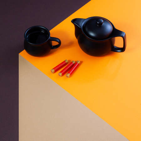 Chinese New Year modern composition with teapot, teacup and firecrackers on imaginary table made out of paper.の写真素材