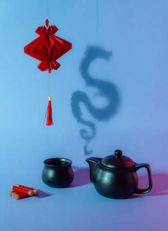 Chinese New Year composition with red paper lantern, teapot, teacup, firecrackers and steamy shadow dragon.の写真素材