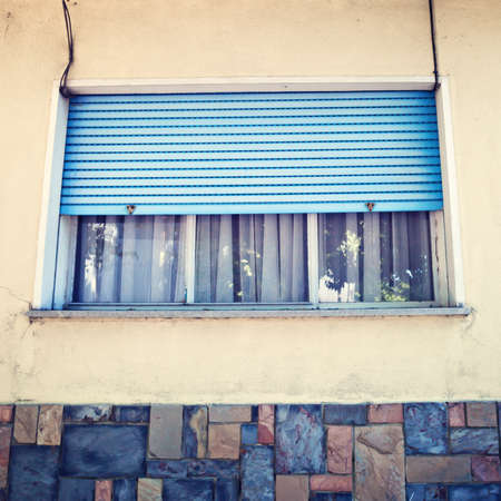 Window with lowered metal blinds