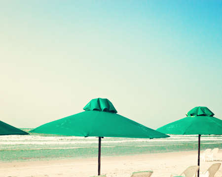 Vintage summer beach with green umbrellasの写真素材