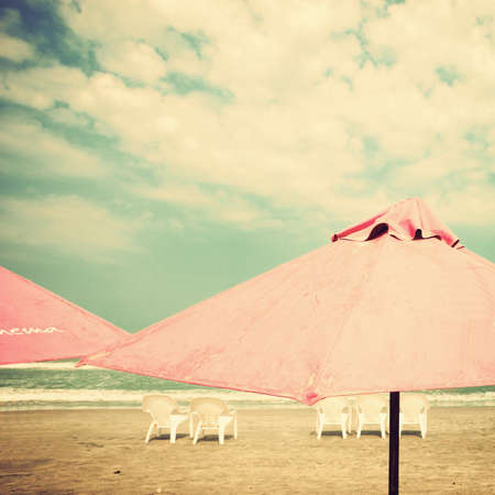Vintage summer beach with pink umbrellasの写真素材
