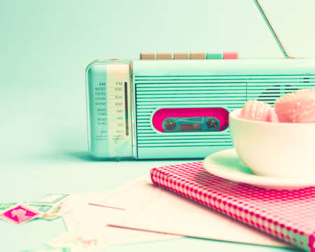 Pink macaroons in a coffee cup and vintage radioの写真素材