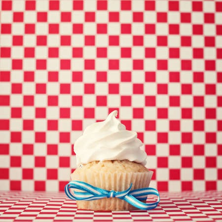 Vanilla cupcake over checkered backgroundの写真素材