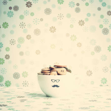 Vintage buttons in a tea cup with mustacheの写真素材