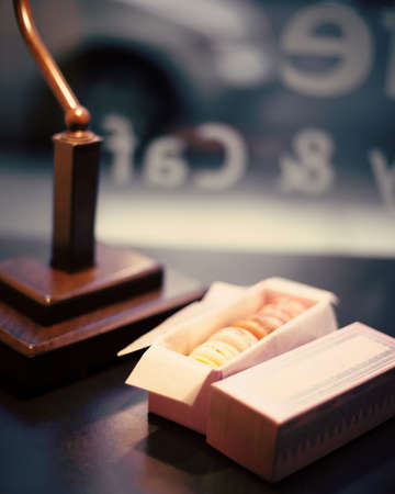 Colorful macaroons in elegant gift box under a lamp