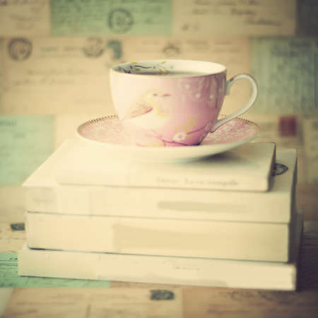 Vintage pink tea cup over booksの写真素材