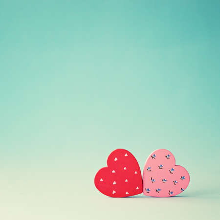Two wood hand-painted hearts over blue backgroundの写真素材