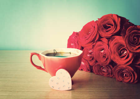 Bouquet of red roses with coffee cup and hand-painted heartの写真素材