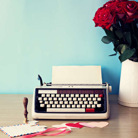 Bouquet of red roses and vintage typewriter