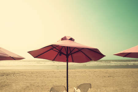 Pink umbrellas in a summer beachの写真素材