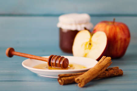Cinnamon, apples and honey over turquoise woodの写真素材