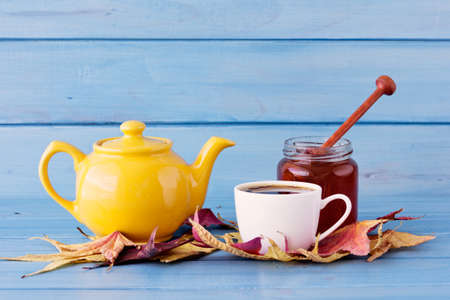Honey, teapot and cup over autumn leafsの写真素材