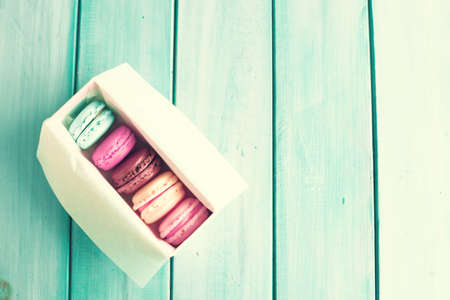 Colorful macaroons in a box over turquoise woodの写真素材