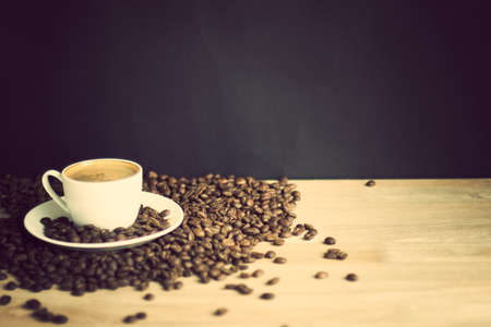 Coffee cup and beans over wood