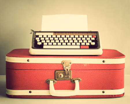 Vintage typewriter over suitcaseの写真素材