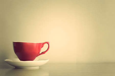 Red coffee cup over white dishの写真素材