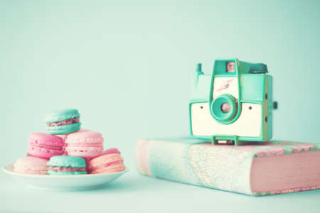 Pastel macarons and camera over bookの写真素材
