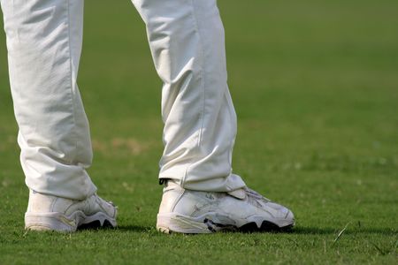 Cricket player stand on green grass in white clothesの写真素材