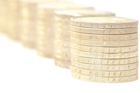 Coins are laid out abreast on a white background.の写真素材