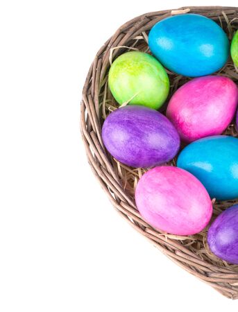 Colorful painted easter eggs in brown basketの写真素材