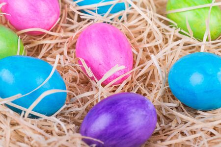 Colorful painted easter eggs in wood shavingsの写真素材