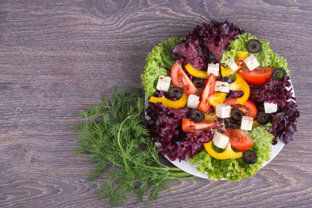 Fresh salad in white plate on wooden backgroundの写真素材