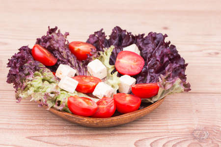 Fresh vegetables with tomatos on a wooden  backgroundの写真素材
