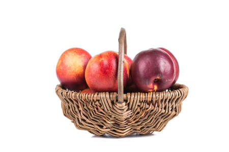 Fresh peaches in a basket on a white backgroundの写真素材
