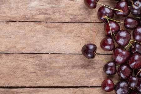 Ripe, red cherry on wooden backgroundの写真素材