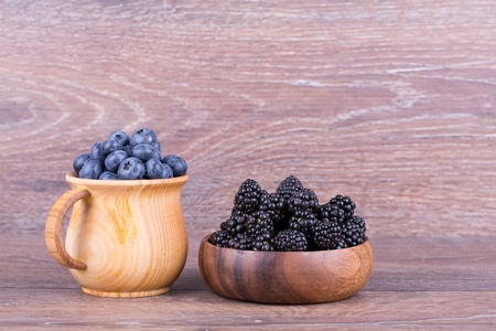 blueberries in wooden bowl on white backgroundの写真素材
