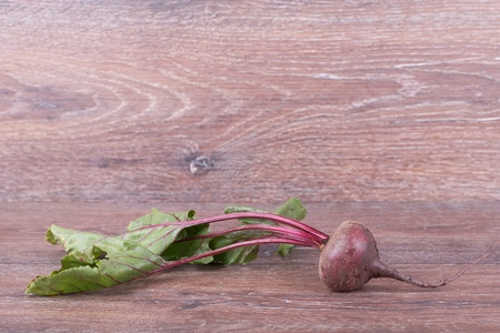 Red beets  with tops on the wooden backgroundの写真素材