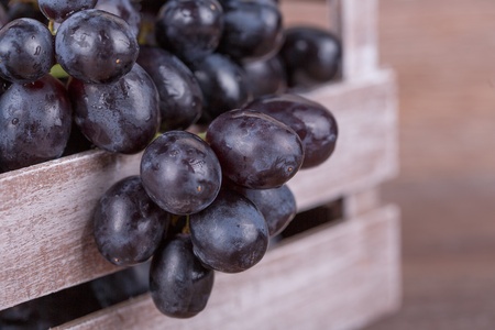Ripe black grapes on a wooden backgroundの写真素材