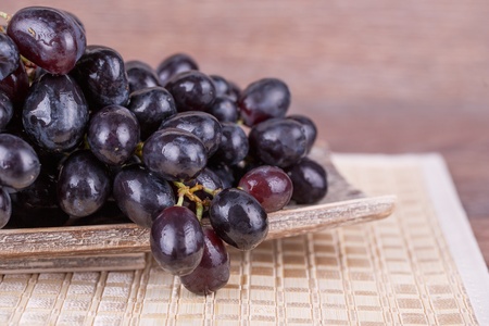 Ripe black grapes on a wooden backgroundの写真素材