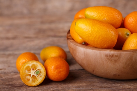 Fresh, ripe, orange kumquats  on wooden backgroundの写真素材