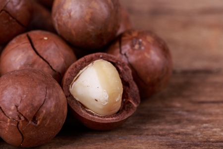 brown macadamia nuts seed on wooden backgroundの写真素材