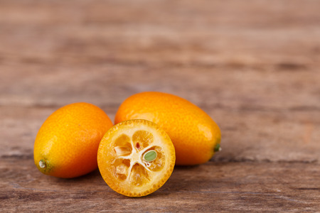 Fresh, ripe, orange kumquats  on wooden backgroundの写真素材