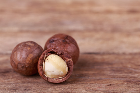 brown macadamia nuts seed on wooden backgroundの写真素材