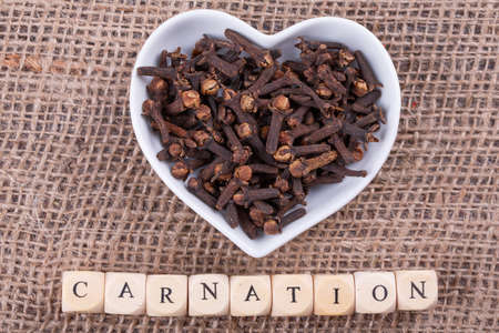 Carnation in  cup in the shape of heart on sack  clothの写真素材
