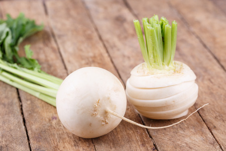 Fresh, White radish with leaves on wooden backgroundの写真素材